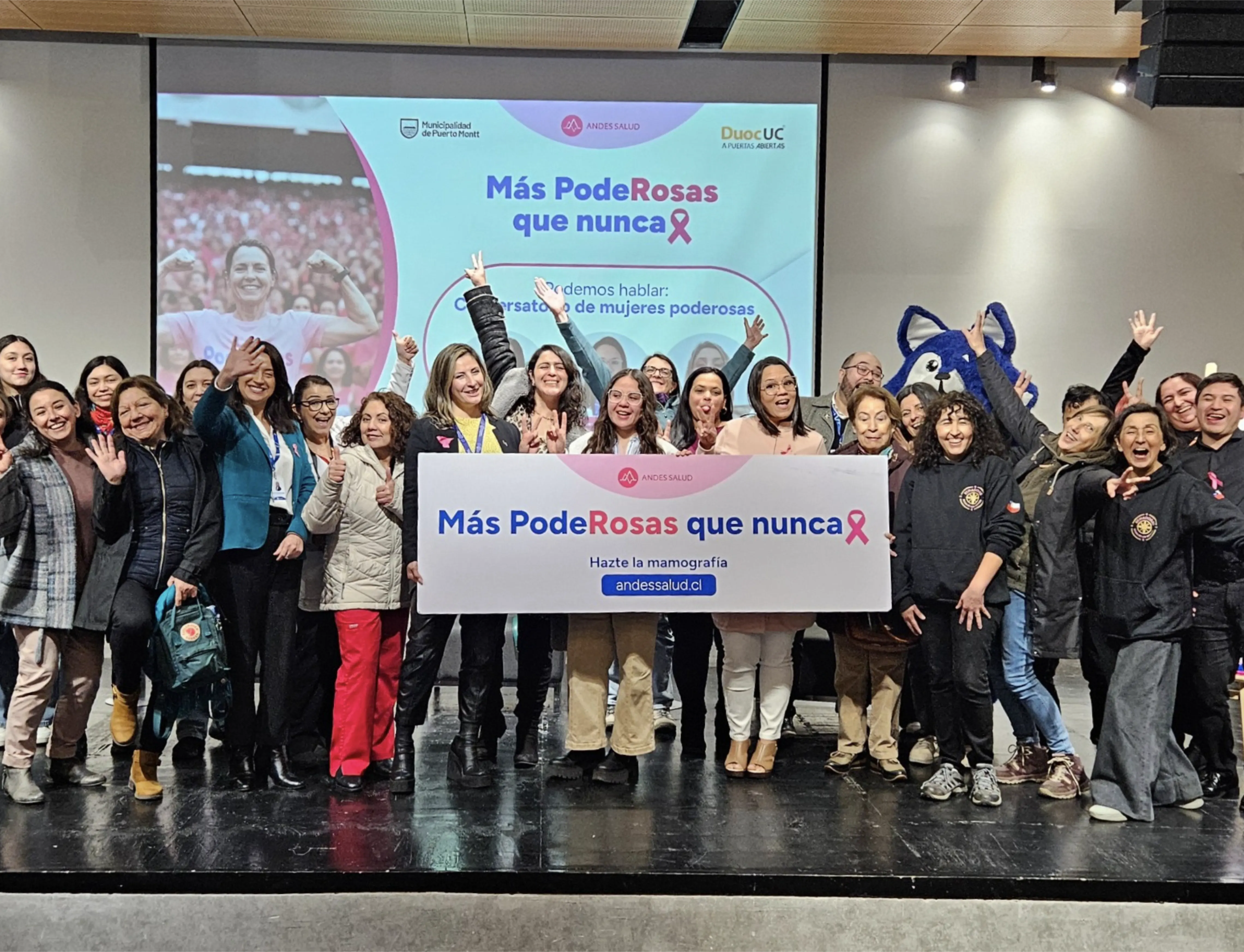 Grupo de mujeres sosteniendo un cartel "Más PodeRosas que nunca" en una activación de Andes Salud.