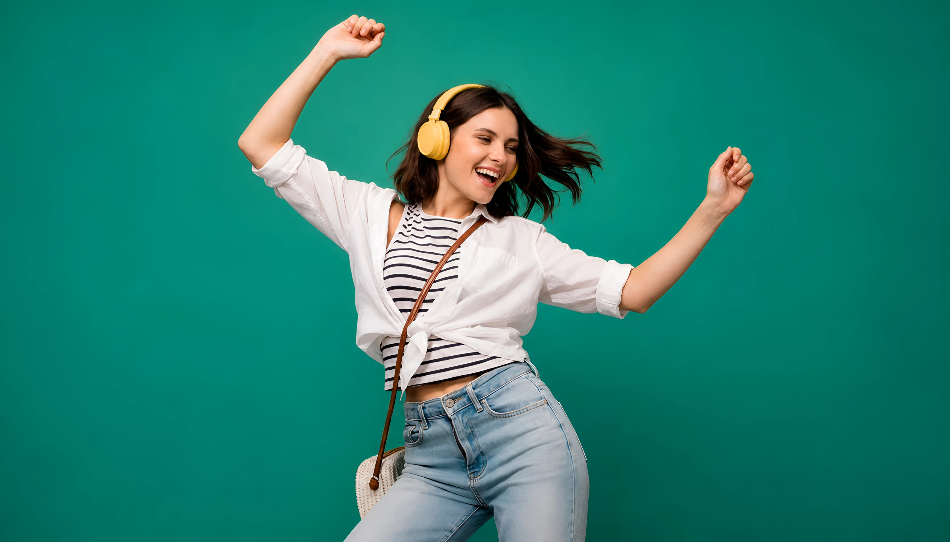 Mujer con audífonos amarillos bailando con energía y alegría