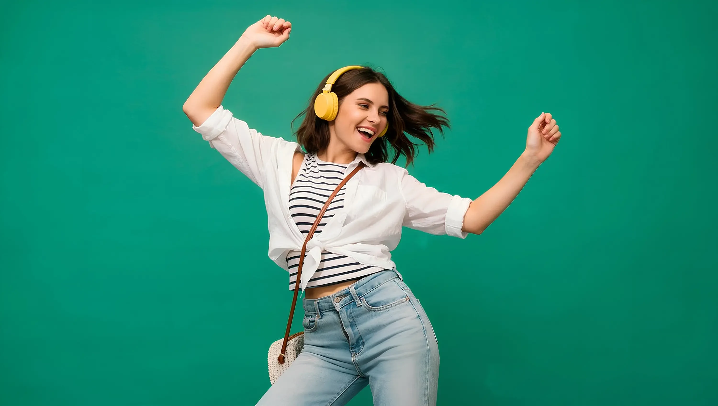 Mujer con audífonos amarillos bailando con energía y alegría